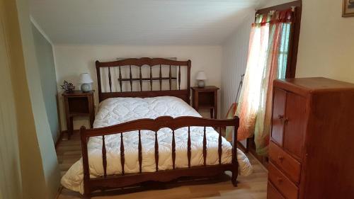 1 dormitorio con cama de madera y vestidor en chez Sandrine et Olivier, en Belvédère