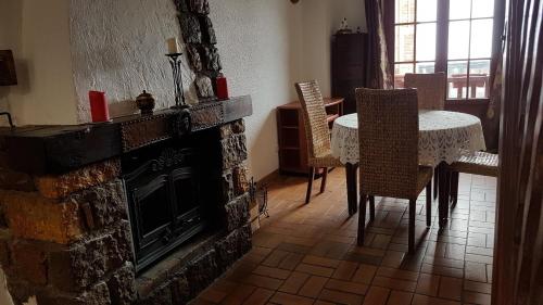 sala de estar con chimenea, mesa y sillas en chez Sandrine et Olivier, en Belvédère