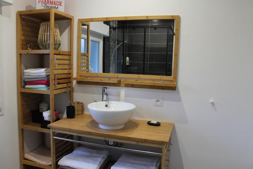 a bathroom with a sink and a mirror and towels at "Mi-a-clo" in Cucq