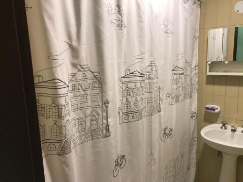un baño con cortina de ducha con un dibujo. en Departamento Belgrano 4 en Salta