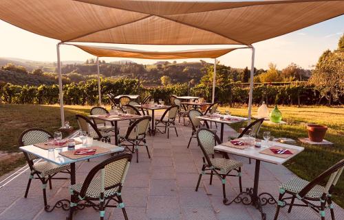 a patio with tables and chairs under a large umbrella at Podere Bellavista in San Gimignano