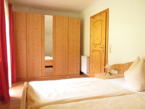 1 dormitorio con cama y espejo grande en Appartement zum Rössl, en Ramsau am Dachstein