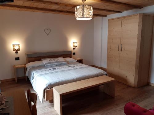 una camera con un grande letto e un armadio in legno di B&B Bucaneve a Vigo di Fassa