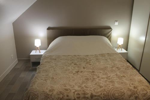 ein Schlafzimmer mit einem großen Bett mit zwei Nachttischen in der Unterkunft "Mi-a-clo" in Cucq