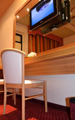 a room with a mirror and a chair and a tv at Hotel Motel 2 in Castel San Giovanni