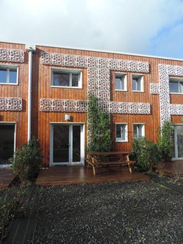a building with a wooden deck in front of it at Résidence Beauvoir le Mont-Saint-Michel (9 gîtes de 2 à 5 personnes) in Beauvoir