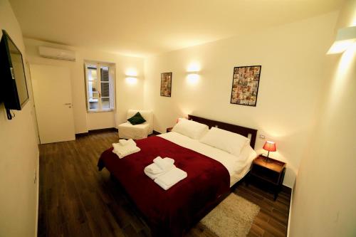 una camera da letto con un grande letto con due asciugamani di Paola's Apartment in the heart of Trastevere, Roma a Roma
