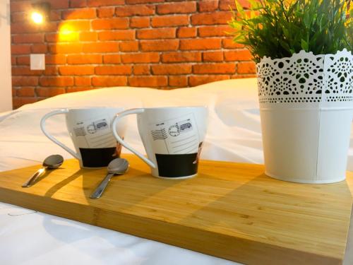 two cups of coffee on a wooden tray with spoons at SWEET APARTMENT CARRIERES - 1 chambre - 4 Pers - Wifi in Carrières-sur-Seine