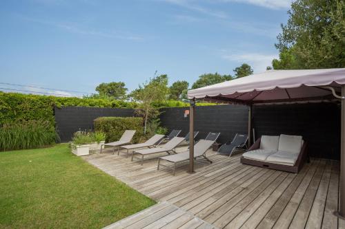 a group of chairs and an umbrella on a wooden deck at Chambre d'Hôtes Etchebri in Anglet