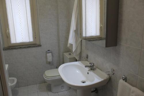 a white bathroom with a sink and a toilet at Casa, Mare-Etna-Taormina in Fondachello