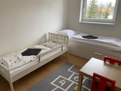 2 camas en una habitación pequeña con mesa y silla en Apartman 37 Vysoke Tatry, en Tatranská Štrba