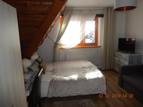 a small bedroom with a bed and a window at U Hanki in Biały Dunajec