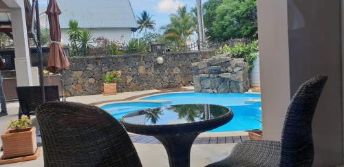 a patio with a table and chairs and a swimming pool at Northern Pearl Luxury Apartments in Mont Choisy