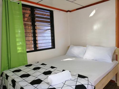 een slaapkamer met een bed en een geruite vloer bij BFF Backpacker's Inn in San Vicente