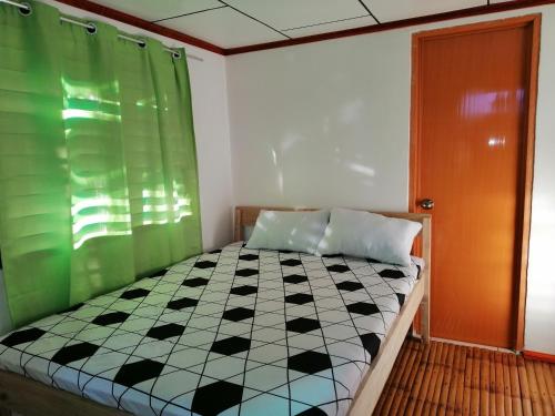 een slaapkamer met een bed en een zwart-wit geruite vloer bij BFF Backpacker's Inn in San Vicente