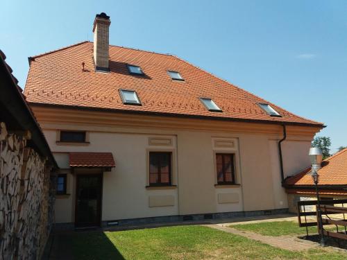 a large white house with a red roof at Penzion Ve Staré škole in Vlastějovice