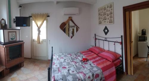 a bedroom with a bed with pink pillows and a television at Casa Panorama Amalfi Coast in Vietri sul Mare