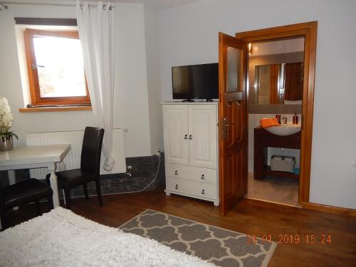 a room with a desk and a table with a television at U Hanki in Biały Dunajec