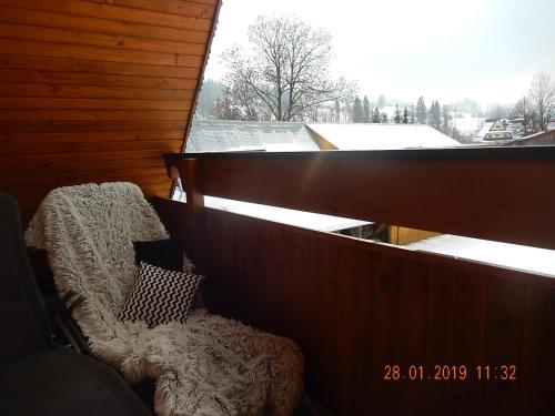 a balcony with a chair and a window at U Hanki in Biały Dunajec