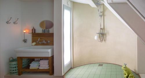 a bathroom with a sink and a shower with a mirror at El Puerto Bed and Breakfast in Hoorn