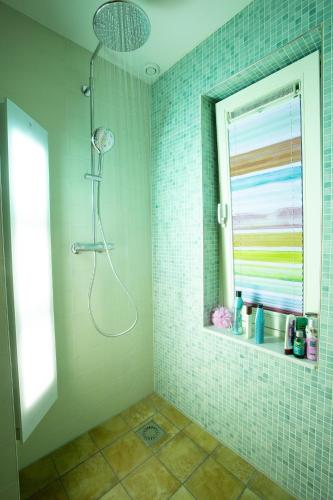 a bathroom with a shower and a window at El Puerto Bed and Breakfast in Hoorn