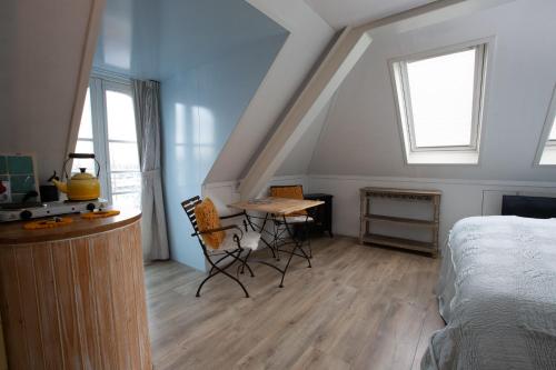 a bedroom with a bed and a table and chairs at El Puerto Bed and Breakfast in Hoorn