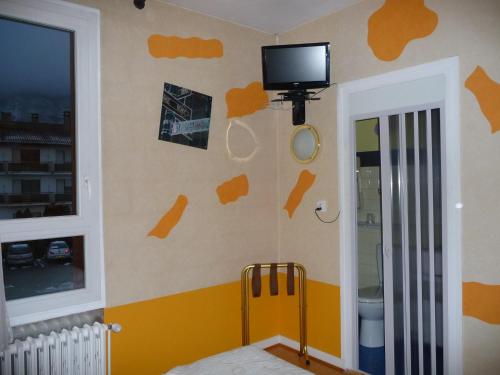 Televízia a/alebo spoločenská miestnosť v ubytovaní Hotel Alain et Martine