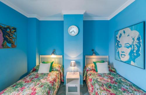 una camera blu con due letti e un orologio a muro di Ático en primera linea Las Canteras a Las Palmas de Gran Canaria