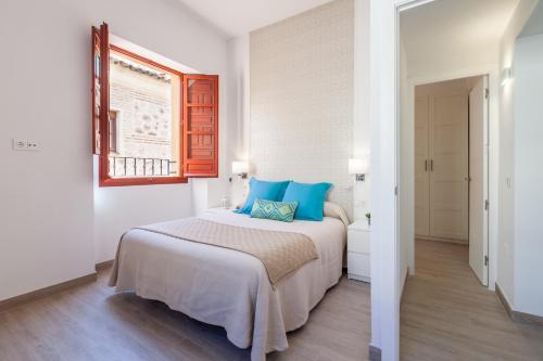 sypialnia z dużym łóżkiem z niebieskimi poduszkami w obiekcie Casa de la Moneda - Center Luxury Duplex w Sewilli