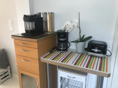 a table with a coffee maker and flowers on it at Moderne Ferienwohnung direkt in Landsberg am Lech in Landsberg am Lech
