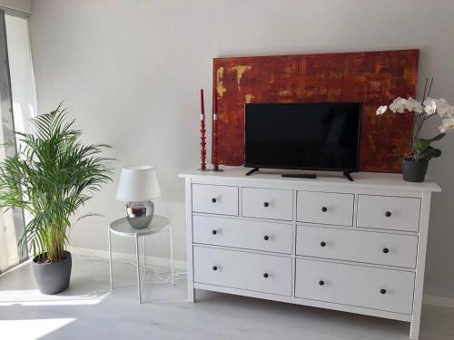 a white dresser with a television on top of it at Moderne Ferienwohnung direkt in Landsberg am Lech in Landsberg am Lech