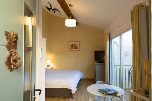 ein Hotelzimmer mit einem Bett und einem Balkon in der Unterkunft Chambre indépendante à Carcassonne in Carcassonne