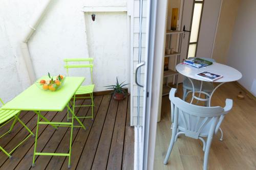 einen kleinen Balkon mit einem Tisch, einem Tisch und Stühlen in der Unterkunft Chambre indépendante à Carcassonne in Carcassonne