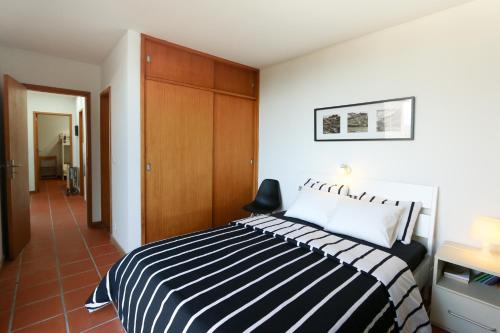 ein Schlafzimmer mit einem schwarz-weiß gestreiften Bett in der Unterkunft Bean House in Vila Nova de Cerveira