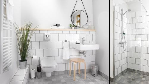 La salle de bains est pourvue d'un lavabo, de toilettes et d'un miroir. dans l'établissement Hôtel Au Petit Pont, à La Wantzenau