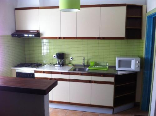 una cocina con fregadero y microondas en Rossio, en Albufeira