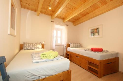 two twin beds in a room with wooden ceilings at Archontiko Kourkoulos in Makrádes