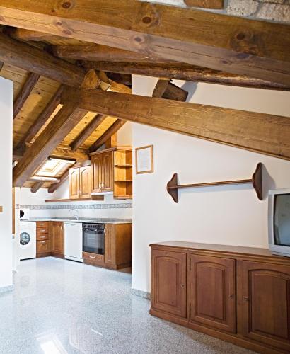 a kitchen with wooden ceilings and wooden cabinets at Apartamentos Casa Buisan in Broto