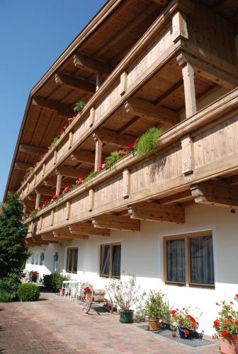 a building with a wooden balcony with plants on it at Sportpension Christina by PiaundDirk in Fügen