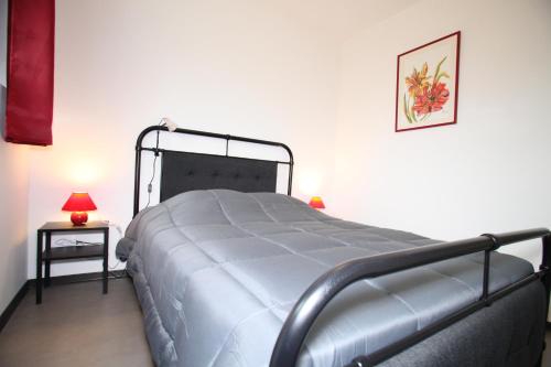 a bedroom with a bed and a side table with a lamp at Résidence Beauvoir le Mont-Saint-Michel (9 gîtes de 2 à 5 personnes) in Beauvoir