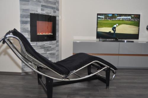 a black chair sitting in front of a tv at Comfort Deluxe Kosmos Apartments in Ohrid