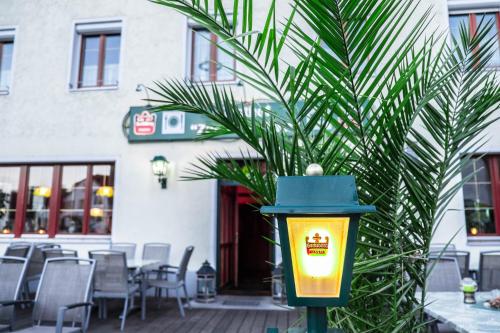 a street light with a palm tree in front of a building at Gasthof zur Alten Post-Pension in Fürstenzell