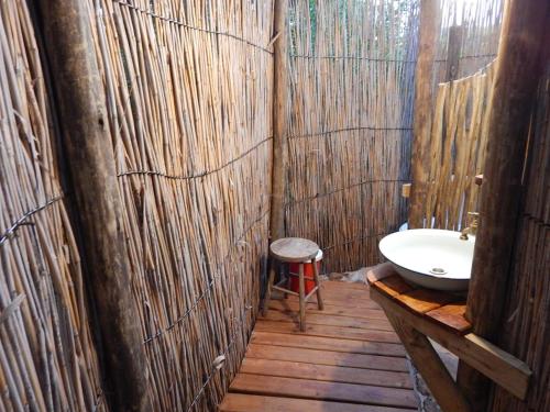 uma casa de banho em madeira com um lavatório e um WC em Woodcutter's Bush Camp at The Old Trading Post em Wilderness