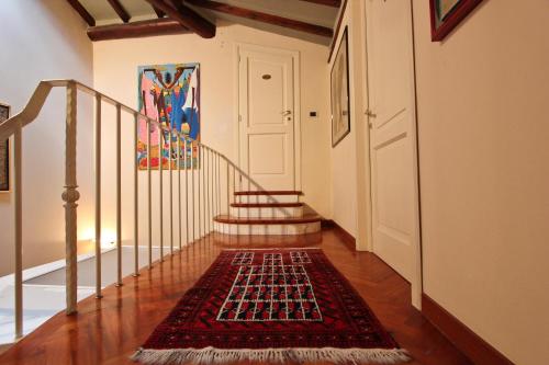 a hallway with a staircase with a rug on the floor at Relais Villa Al Vento in Incisa in Valdarno