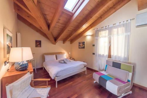 1 dormitorio con cama, sofá y ventana en Casa dei Mulini, en Mergozzo