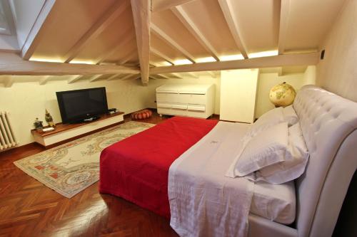 a bedroom with a large bed and a television at Relais Villa Al Vento in Incisa in Valdarno