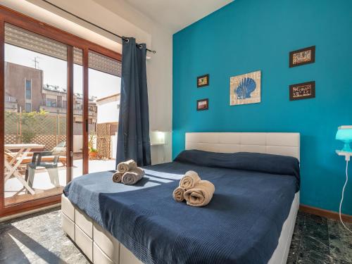 カリアリにあるTerrazza Bonariaの青い壁のベッドルーム1室、ベッド1台(タオル付)