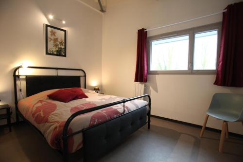 a bedroom with a bed and a window and a chair at Résidence Beauvoir le Mont-Saint-Michel (9 gîtes de 2 à 5 personnes) in Beauvoir