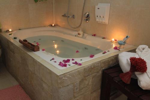 a bath tub with candles and flowers in a bathroom at Rosh Pinat Noy in Rosh Pinna