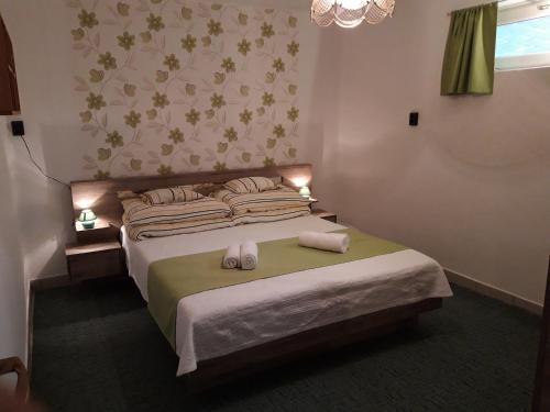 a bedroom with a bed with two towels on it at Eszter Vendégház in Tiszafüred